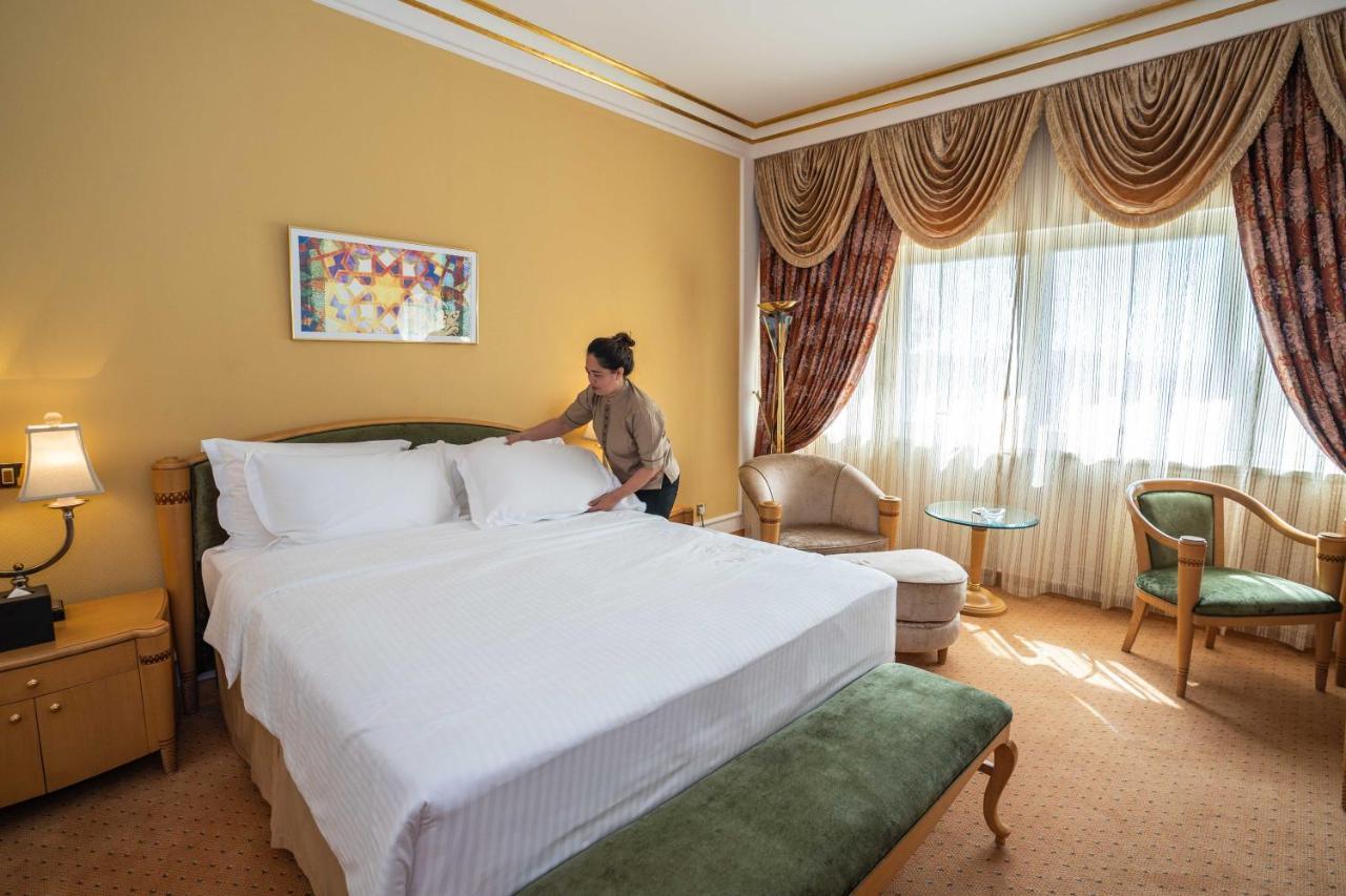 ออฟฟิตเซอร์ คลับ&โฮเต็ล Hotel อาบูดาบี ภายนอก รูปภาพ A chambermaid making a bed in a hotel room